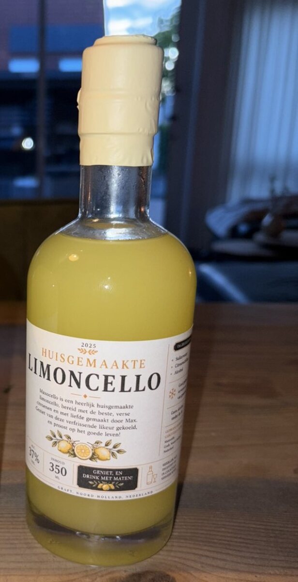 Een fles Maxocello limoncello op een houten tafel, verzegeld met gele was